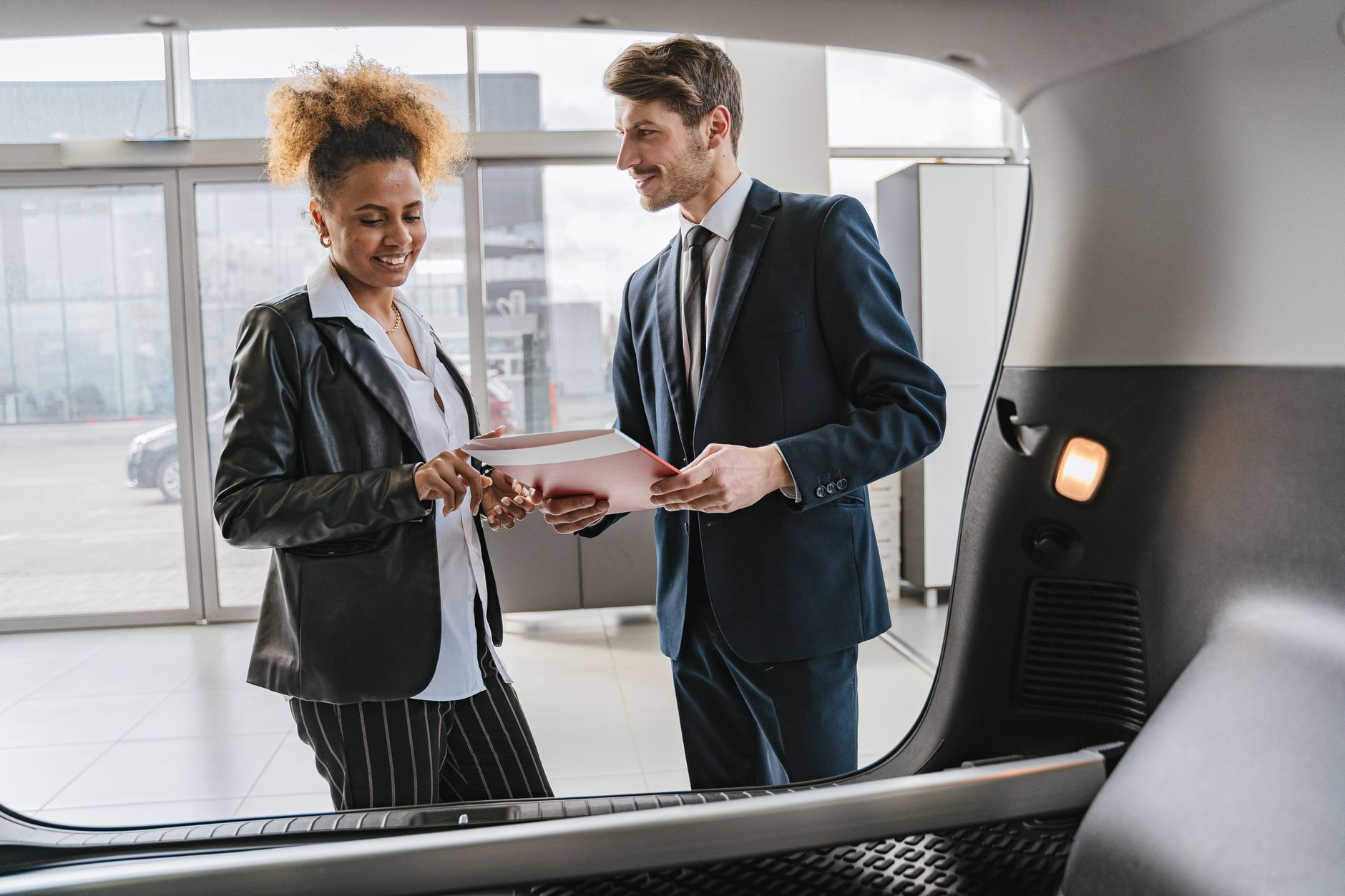 Customer reviewing Dubai car sale requirements with a dealership advisor